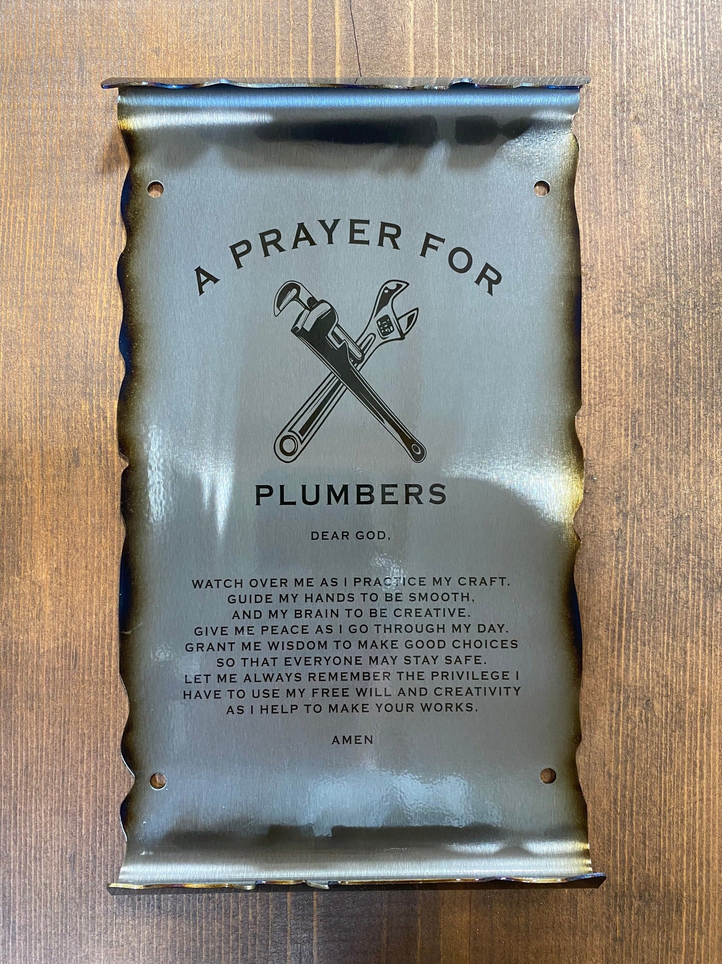 CNC cut metal Plumber’s Prayer scroll with heat patina finish and powder coat, made from American steel