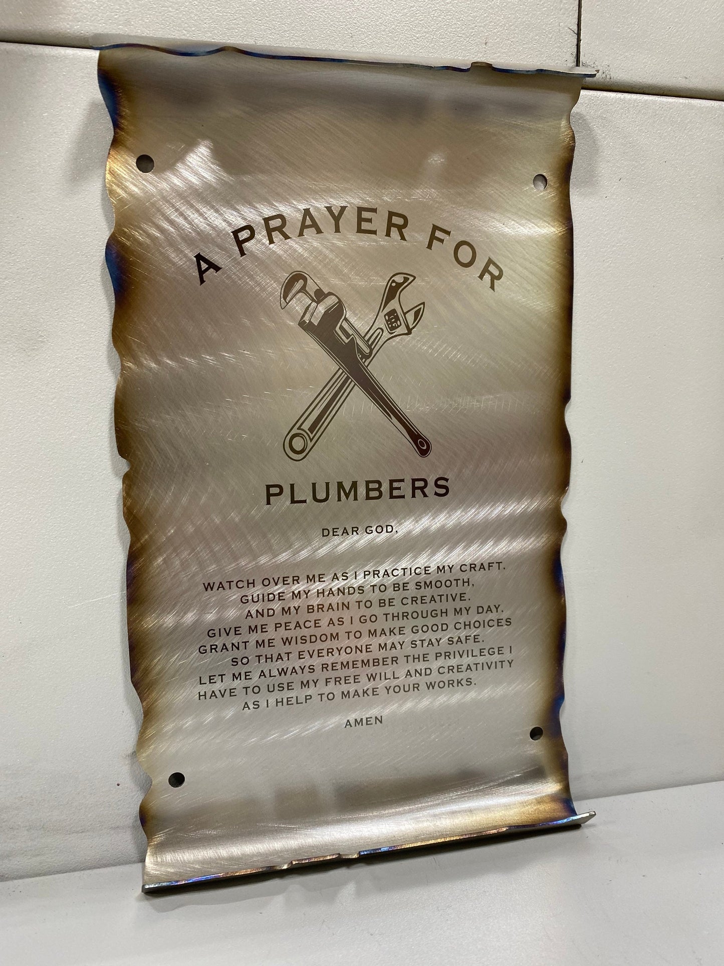 CNC cut metal Plumber’s Prayer scroll with heat patina finish and powder coat, made from American steel