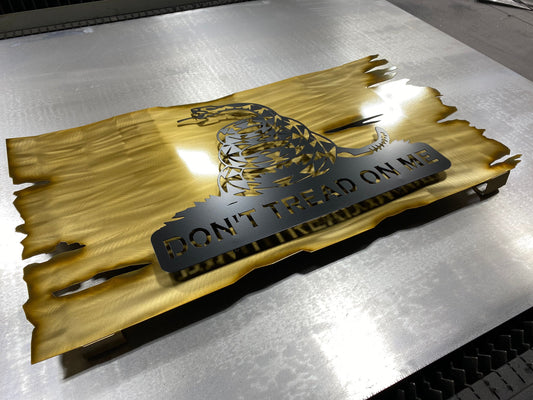 Distressed yellow metal Gadsden flag with Don’t Tread on Me design

