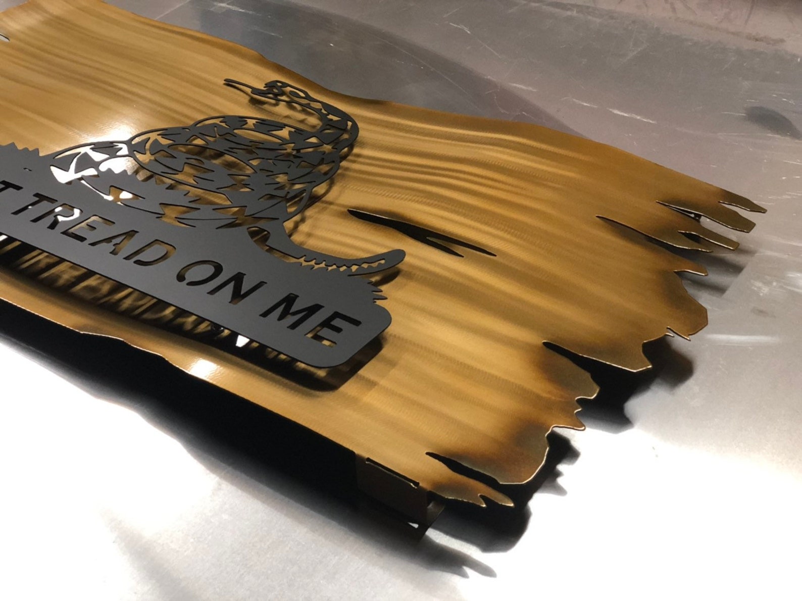 Distressed yellow metal Gadsden flag with Don’t Tread on Me design