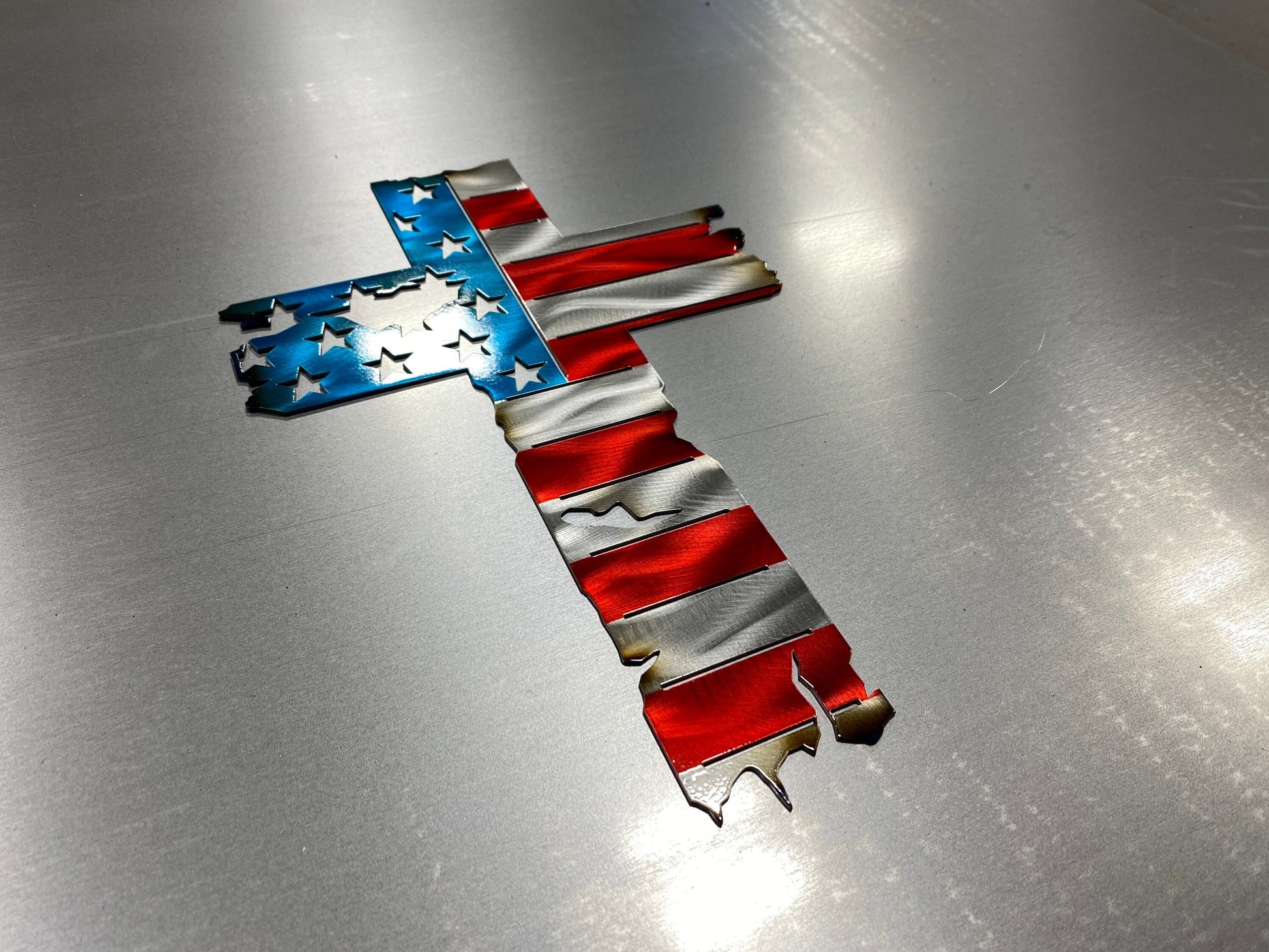 Metal cross wall decor with tattered American flag overlay

