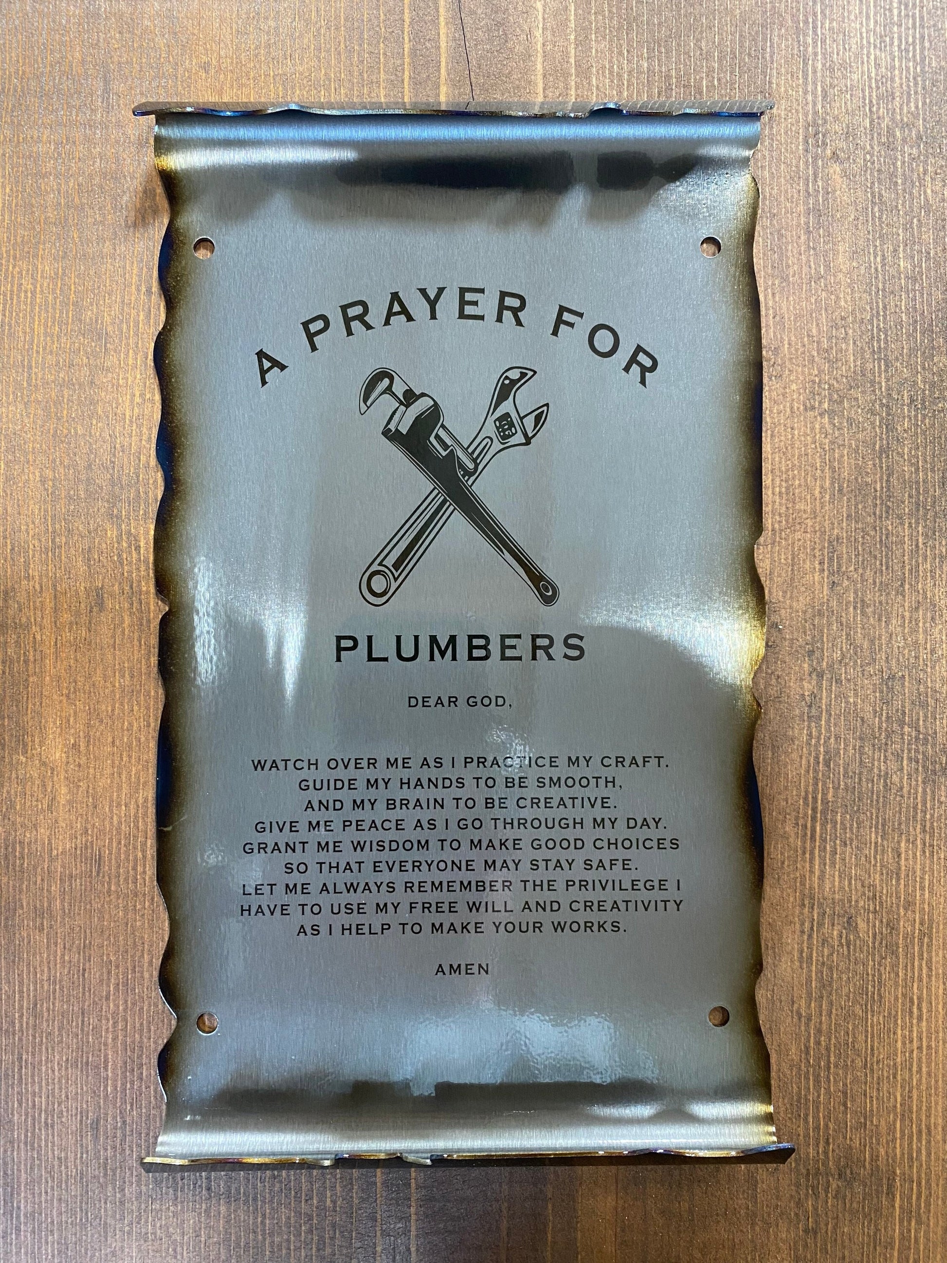 CNC cut metal Plumber’s Prayer scroll with heat patina finish and powder coat, made from American steel

