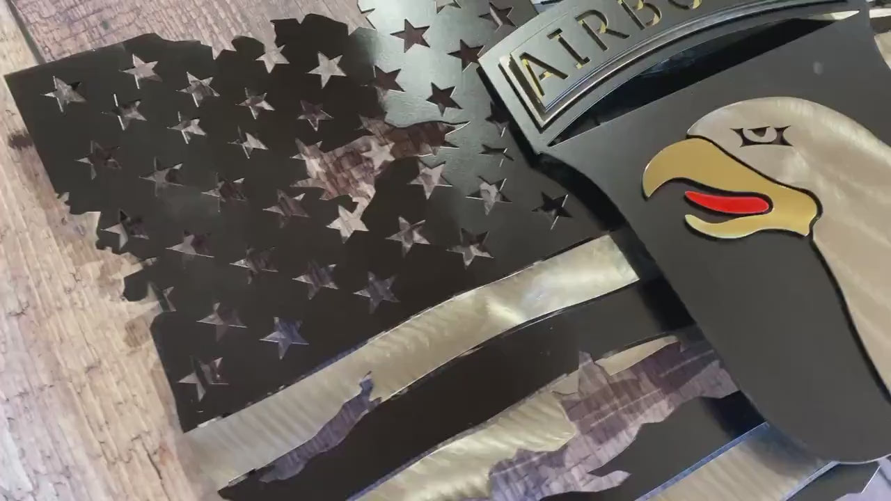 Tattered metal American flag featuring the 101st Airborne Division emblem in black and silver.