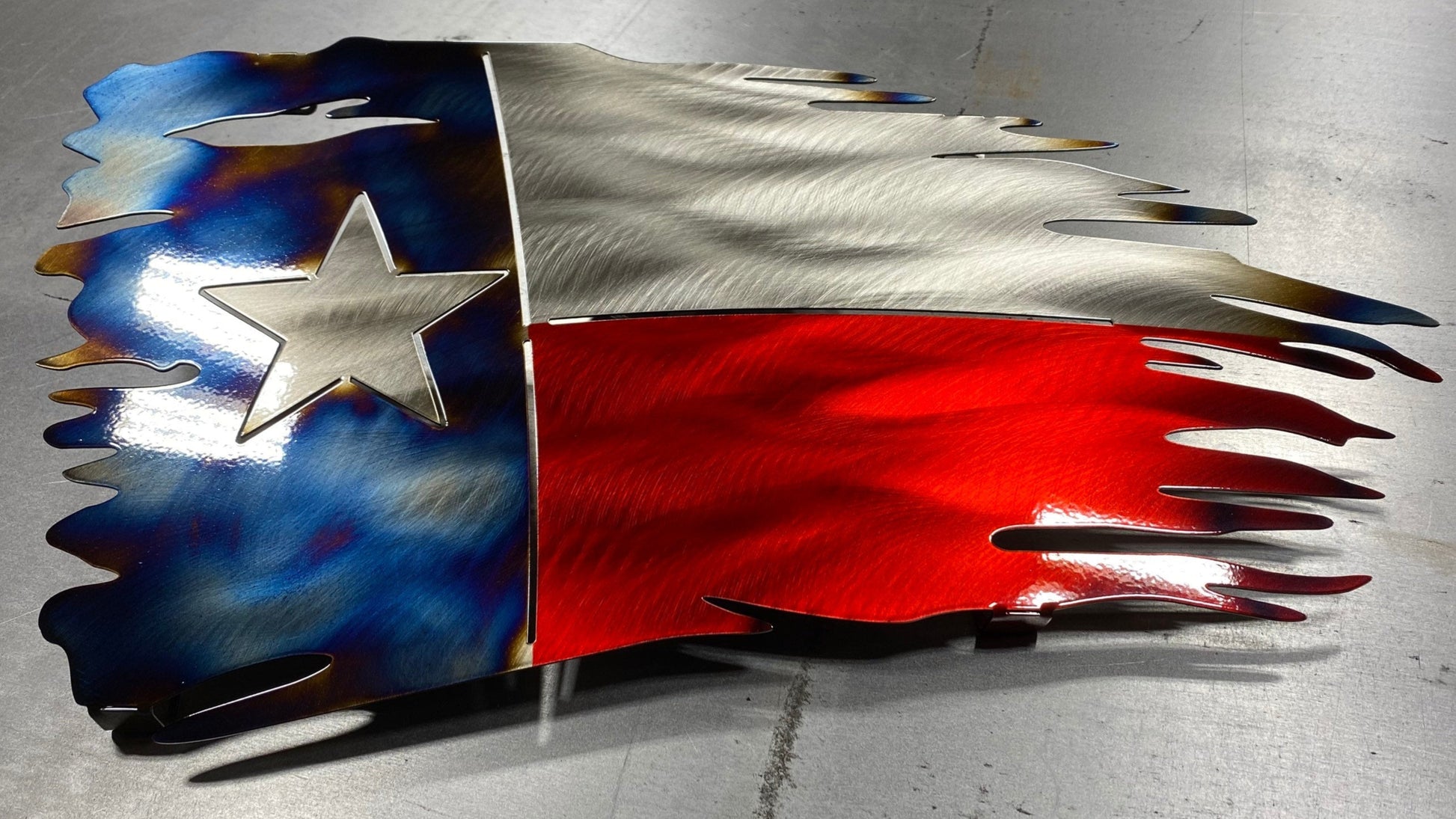 Tattered Texas flag made of metal with red, white, and blue powder coat