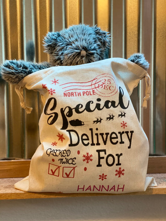 Personalized Santa sack with recipient’s name, DTG printed holiday gift bag measuring 14 by 12 inches
