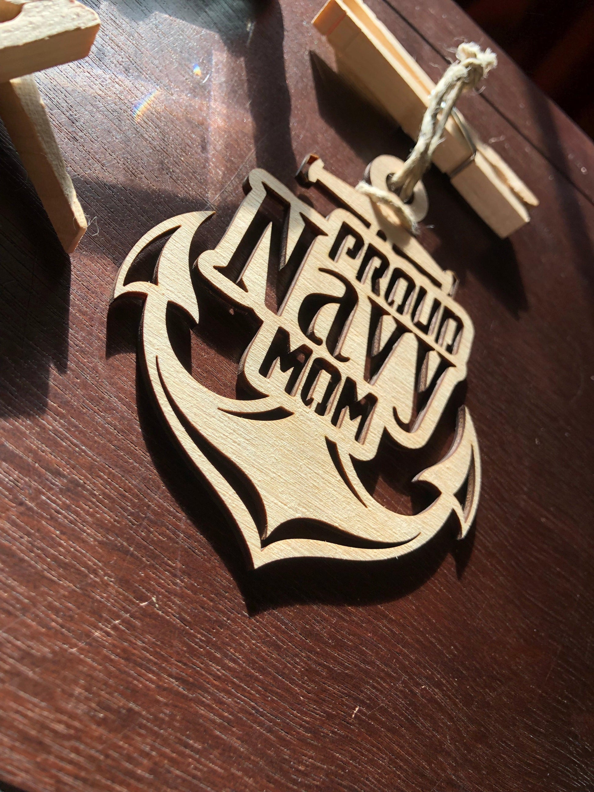Proud Navy Mom ornament laser-cut from Baltic Birch, featuring intricate details and perfect for Christmas tree display.